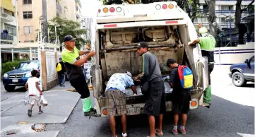  ??  ?? File photo shows children scavenge for food in a rubbish truck in Caracas, Venezuela. — Reuters photo