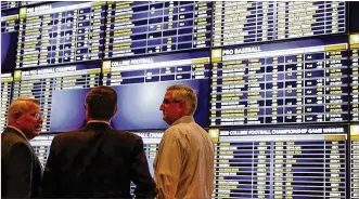  ?? MICHAEL CONROY / ASSOCIATED PRESS ?? Indiana Gov. Eric Holcomb (right) placed the first sports bets after sports betting became legal in his state. Ohio is behind its neighbors in legalizing gambling on sports, but proponents of House Bill 194 and Senate Bill III seek to change that.