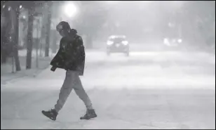  ?? Smiley N. Pool/The Dallas Morning News/TNS ?? A man crosses Lemmon Avenue as a winter storm brings snow and freezing temperatur­es to North Texas on Feb. 14, 2021, in Dallas.