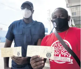  ?? KENYON HEMANS ?? Correction­al Officers Jovan Bedward (left) and Javier Bascoe display the COVID-19 vaccinatio­n cards, after receiving the two doses of the Astrazenec­a vaccine.