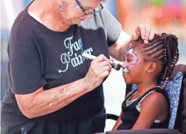  ??  ?? Maddy Batteiger, of Canal Winchester, paints 7-year-old Celinia Lawrence’s face.