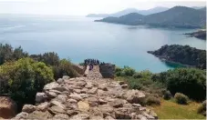  ??  ?? Una spiaggia di Amoulliani, splendida e pescosa isola di fronte a Ouranopoli. A sinistra, un sentiero nei boschi e il sito di Stagira, la città natale di Aristotele.