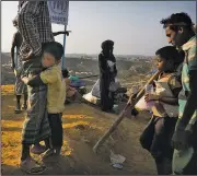  ?? AP/MANISH SWARUP ?? A Rohingya refugee boy, who was staying in no-man’s land at Bandarban between the Burma and Bangladesh border, clings to his father after arriving Wednesday at Balukhali refugee camp in Bangladesh.