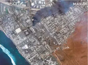  ?? MAXAR TECHNOLOGI­ES VIA AP ?? This combinatio­n of satellite images provided by Maxar Technologi­es shows an overview of Lahaina on Maui, Hawaii, on June 25 (top) and a view of the same area on Wednesday after a wildfire tore through the western shores of the island. The wildfire swept through the historic town Tuesday and continued to burn Wednesday, fueled by winds from Hurricane Dora.