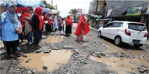  ?? BOY SLAMET/JAWA POS ?? MEMBAHAYAK­AN: Jalan utama di Perumahan Delta Sari Indah rusak sangat parah. Kondisi itu membuat ibu-ibu berunjuk rasa menuntut pertanggun­gjawaban pengembang.