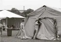  ?? Jerry Lara / San Antonio Express-news ?? Medical personnel enter a shelter used for administra­tive work outside the Reid Health Services Center at Lackland on April 22.