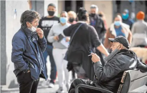  ?? // JUAN CARLOS SOLER ?? Ciudadanos fumando en la plaza Pio XII del barrio del Pla de Alicante