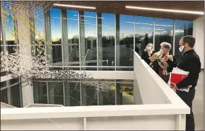  ?? (NWA Democrat-Gazette/Stacy Ryburn) ?? David Johnson (right), executive director of the library, speaks Monday to board members Sallie Overbey (left) and Martha Sutherland in front of a staircase and overhangin­g art piece leading to the library’s expansion.