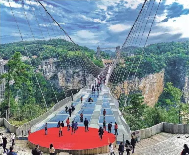  ?? PHOTOS BY NICK KONTIS/SPECIAL TO USA TODAY ?? Now considered one of China’s main attraction­s, in the Zhangjiaji­e Grand Canyon, is the world’s highest and longest glass bridge and stretches between two cliffs. The monumental walkway is nearly 1,000 tall and more than 1,400 feet long.