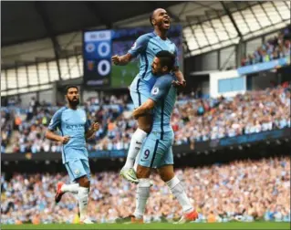  ?? GARETH COPLEY, GETTY IMAGES ?? Manchester City’s Raheem Sterling, centre, jumps for joy as he celebrates scoring the opening goal with Nolito against West Ham United at Etihad Stadium in Manchester, England, on Sunday.