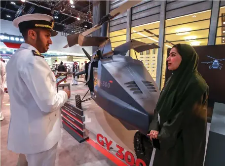  ?? Victor Besa / The National ?? A visitor learns about the GY 300 helicopter drone at the Edge stand at Umex and Simtex