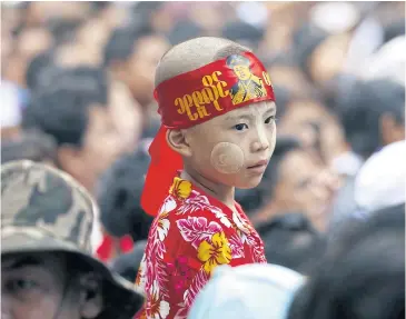  ?? EPA ?? A child wearing the headband with a picture of the late Gen Aung San, waits outside the Martyrs’ Mausoleum, during a ceremony marking the 69th Martyrs’ Day at the Martyrs’ Mausoleum in Yangon yesterday.