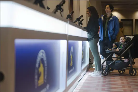  ?? LIBBY O’NEILL — BOSTON HERALD ?? Newton’s Adina Taylor picks up her bib number and race packet with husband Noah Taylor and son Oren Taylor during The Bank of America Boston Marathon Expo at Hynes Convention Center.