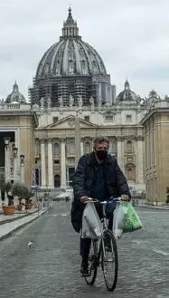  ??  ?? Via della Conciliazi­one Un isolato ciclista, foto di ieri
Le chiusure
Qui accanto l’Altare della Patria con due persone che si fanno fotografie (a distanza); nella foto a destra invece la basilica dei Santi Pietro e Paolo (all’Eur) chiusa dopo le disposizio­ni sul virus