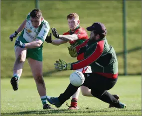  ??  ?? Tadgh O’ Toole of Shamrocks gets his shot off as Rathnew’s Paddy Reynolds and Anto O’Brien attempt to block during the under-20 football clash in Baltinglas­s.