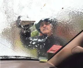  ??  ?? Omar Elkhalidi scrapes ice off his windshield Wednesday in Savannah, Ga. Snow fell in the city for the first time since 2010. STEPHEN B. MORTON/AP