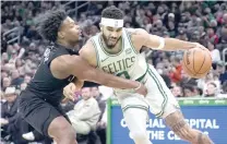  ?? CHARLES KRUPA/AP PHOTO BY ?? Boston Celtics forward Jayson Tatum (right) drives to the basket against Brooklyn Nets guard Dennis Smith Jr. during the first half of an NBA basketball game, Wednesday, Feb. 14, 2024, in Boston.