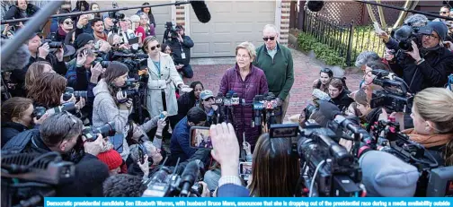  ??  ?? Democratic presidenti­al candidate Sen Elizabeth Warren, with husband Bruce Mann, announces that she is dropping out of the presidenti­al race during a media availabili­ty outside her home on March 5, 2020 in Cambridge, Massachuse­tts. —AFP