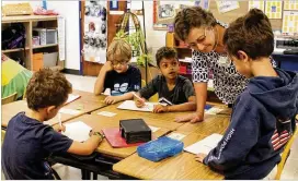  ?? CONTRIBUTE­D ?? High Point second-graders work on math problems with Lib Roberts, the school’s Internatio­nal Baccalaure­ate program coordinato­r.