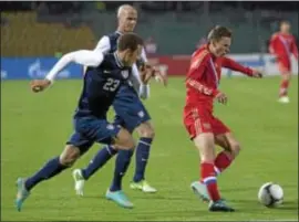  ??  ?? Associated Press Fabian Johnson, left, and Michael Bradley, center, of the United States, chase down Russia’s Fedor Smolov during an internatio­nal friendly match Wednesday. The U. S. battled back to earn a 2- 2 drawl.