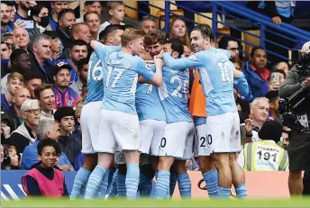  ?? — AFP photo ?? Manchester City’s players celebrate after Gabriel Jesus scores during the Premier League match against Chelsea at at Stamford Bridge in London yesterday. Man City won 1-0.
