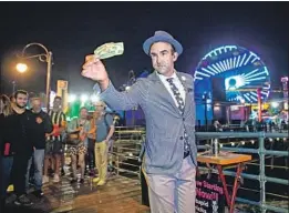  ?? Allen J. Schaben Los Angeles Times ?? MAGICIAN Frank DeVille performs tricks before a crowd on the Santa Monica Pier after being selected out of a daily lottery for one of 24 designated spaces.