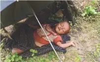  ?? AFPPIX ?? A child sleeps after crossing the border from Myanmar, near the Bangladesh­i town of Teknaf on Sunday.