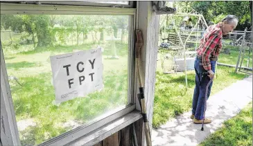  ?? PHOTOS BY RODOLFO GONZALEZ / AMERICAN-STATESMAN ?? At his Austin home, Coney Dorough uses a cane to steady himself after walking past oversized letters taped to the back porch. They are part of the exercises he uses for the eye with a telescope.