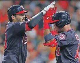  ?? John G. Mabanglo EPA/Shuttersto­ck ?? A SOLO home run by Kurt Suzuki, left, gave the Nationals a 3-2 lead in the seventh inning before they broke it open. Victor Robles celebrates with Suzuki.