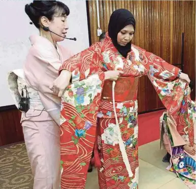  ?? PIC BY SAIFULLIZA­N TAMADI ?? UPM students attend a demostrati­on on how to wear a kimono.