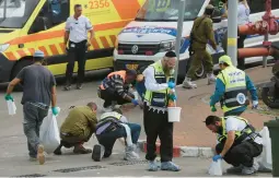  ?? OREN ZIV/AP ?? Israeli soldiers and members of the Zaka paramedic service clean blood from the site of a deadly attack Tuesday near the West Bank Jewish settlement of Ariel.