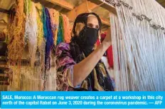  ?? — AFP ?? SALE, Morocco: A Moroccan rug weaver creates a carpet at a workshop in this city north of the capital Rabat on June 3, 2020 during the coronaviru­s pandemic.