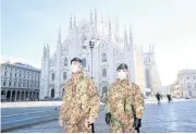  ?? REUTERS ?? Military officers wearing face masks stand outside Milan’s Duomo cathedral.