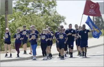  ?? PHOTOS BY JOEL ROSENBAUM — THE REPORTER ?? Members of the Vacaville Police Department cross the Nut Tree Road overpass as they turn onto East Monte Vista Avenue while carrying the Special Olympics Torch Monday during their leg of the 2022Specia­l Olympics Northern California’s Law Enforcemen­t Torch Run.