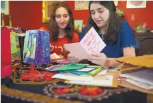  ??  ?? Sigalle Bahary, 20, left, and Yael Perlman, 18, look through sympathy cards sent from around the world after an attacker killed 11 at a Pittsburgh synagogue in October 2018.