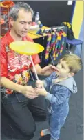  ??  ?? Left, Tom Kellett teaches Bradley Mullen, two, how to spin plates; right, Charlotte Gardner paints nine-year-old Olivia’s face