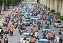  ?? AP ?? Motorbikes and cars fight for space on a street in Hanoi, Vietnam. The city could join the Formula One circuit next year and witness high-powered cars on street circuit.