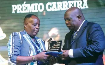  ??  ?? DOMBELE BERNARDO | EDIÇÕES NOVEMBRO Robertinho (à esquerda) recebeu o troféu das mãos do governador Adriano Mendes de Carvalho