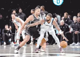  ?? ?? l Kyrie Irving es marcado por el base de los Nets de Brooklyn Dennis Smith Jr.