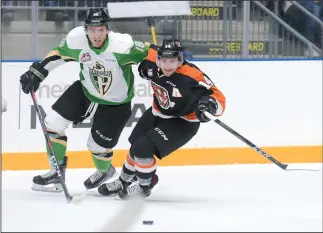  ?? NEWS PHOTO RYAN MCCRACKEN ?? Medicine Hat Tigers winger Ryan Jevne (14) and Prince Albert Raiders centre Noah Gregor battle for a puck during the first period of Wednesday's Western Hockey League game at Canalta Centre.