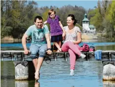  ??  ?? André, Laura und Daniela Seidelmann strecken schon mal den Zeh ins Wasser des Kuhsees. Für den Rest ist es ihnen noch zu kalt.