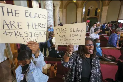  ?? RINGO H.W. CHIU — THE ASSOCIATED PRESS FILE ?? People hold signs and shout slogans before the starting the Los Angeles City Council meeting on Tuesday, Oct. 11, 2022 in Los Angeles. Cross-cultural coalitions have ruled Los Angeles politics for decades, helping elect both Black and Latino politician­s to top leadership roles in the racially and ethnically diverse second largest city in America. But the year old recording of racist comments by the city’s City Council president has laid bare the tensions over political power that have long quietly simmered between the Latino and Black communitie­s.