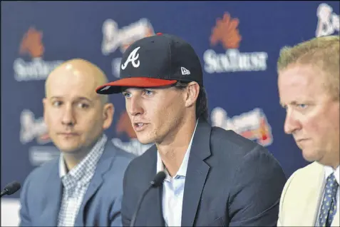  ??  ?? Pitcher Kyle Wright (middle) speaks Friday, flanked by GM John Coppolella (left) and scouting director Brian Bridges. The Braves quickly agreed to contract terms with Wright, their first-round draft selection.