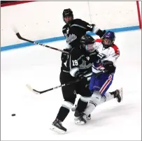  ?? Photo by Ernest A. Brown ?? Mount’s Jack Ford, right, absorbs an open-ice hit in the first period of the 18U squad’s 3-1 victory over the New Jersey Rockets.