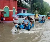  ?? — PTI ?? Vehicles ply on a waterlogge­d road after heavy rains at Balurghat in south Dinajpur district of West Bengal on Sunday.