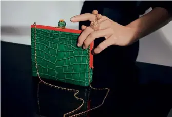  ??  ?? DOUBLE DUTY Rounding off this collection is a sleek bag made of green alligator leather, topped with a dramatic cactus clasp that doubles as a brooch