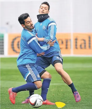  ??  ?? Festgedrib­belt: Ilkay Gündogan (li.) und Mesut Özil bei einem Training im DFB-Dress 2015.