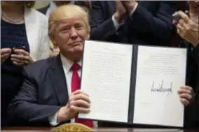  ?? ANDREW HARNIK — THE ASSOCIATED PRESS ?? President Donald Trump holds the signed Education Federalism Executive Order during a federalism event with governors in the Roosevelt Room of the White House in Washington, Wednesday, April 26, 2017.
