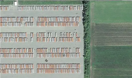  ?? GOOGLE EARTH ?? Red and orange trucks in a Coteau- du- Lac warehouse parking lot adjacent to farmland were among three Off Island areas featured in The Atlantic’s photograph­y blog, In Focus. “It looked almost like an abstract painting,” said Alan Taylor, a senior...