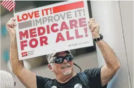  ??  ?? Retired ER doctor James Winkler protests Friday in Denver. | AP